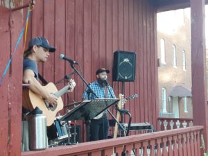 A guitar player and a banjo player at microphones.